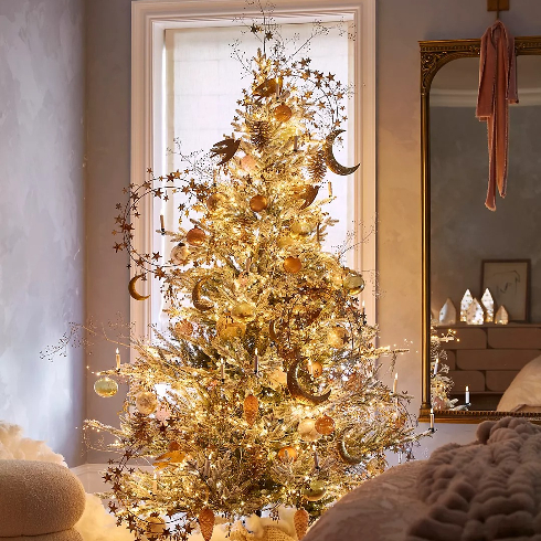 A faux snowy-looking artificial Christmas tree with golden twinkle lights