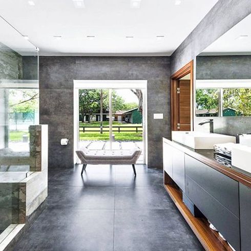 Celebrity homes - The primary bathroom has a double sink, while the walls are covered in stunning grey stone with a large glass shower that’s a spa-like oasis in Gisele Bündchen’s $9.1M Florida Equestrian Estate