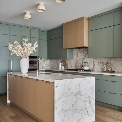 Green cabinets and marble in kitchen