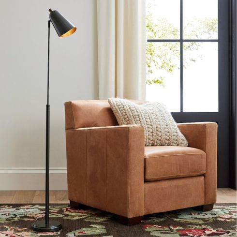 Pottery Barn's Statuesque Metal Lamp next to a camel-coloured couch