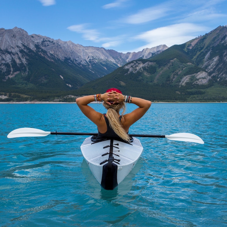 Woman in a kayak looking at the mountains