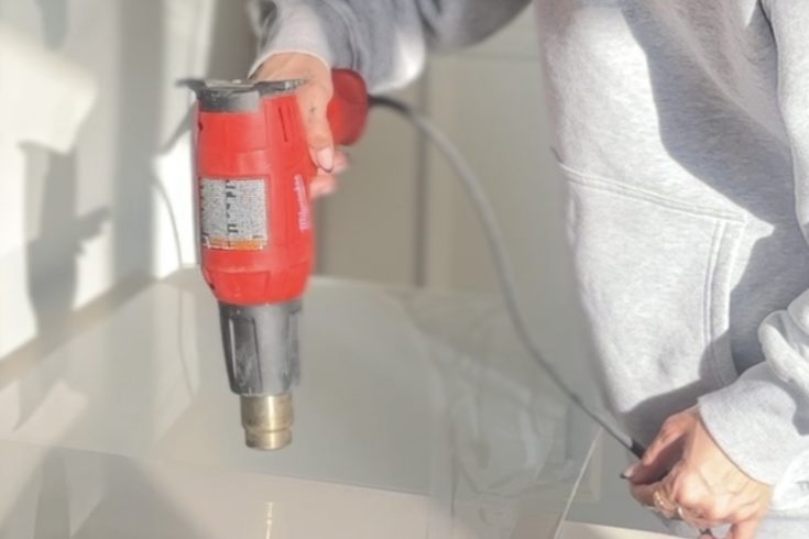 Heat gun being used on plexiglass for DIY project