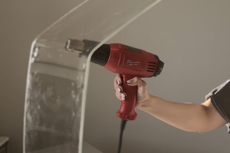 Heat gun being using to bend plexiglass for DIY side table
