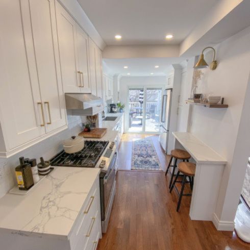White galley kitchen with small mounted seating area