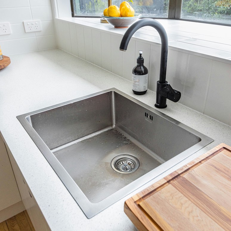 Stainless steel kitchen sink with black faucet