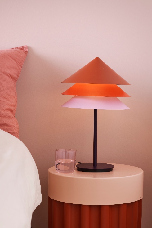 A modern lampshade with three stacked shades in dark orange, light orange and light pink.