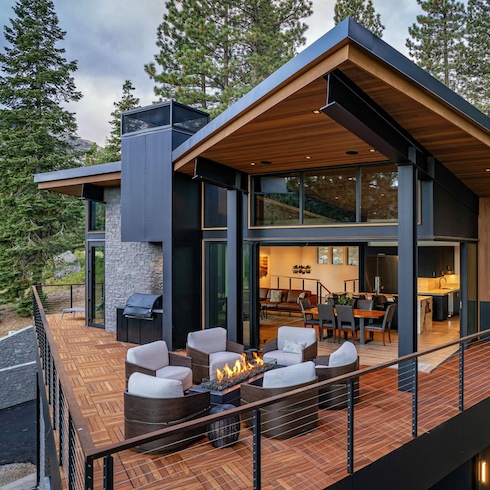 A stunning addition to any outdoor living area, DreamCast’s Linea 72 Fire Table, shown here at Donner Lake, Truckee, California, is the focal point of the outdoor balcony at a luxury mountain chalet with black, stone and dark wood exterior