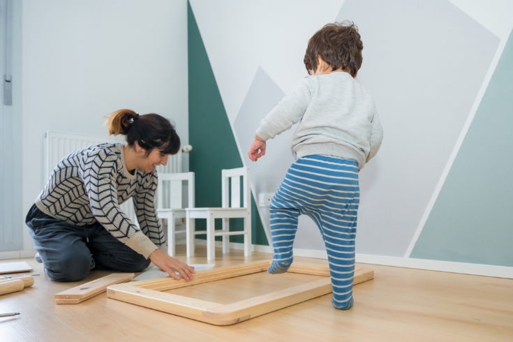A mother building furniture for her young son's bedroom