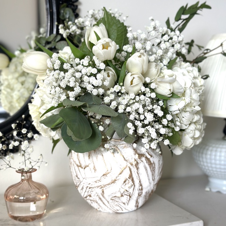 White roses in a white textured cermaic vase