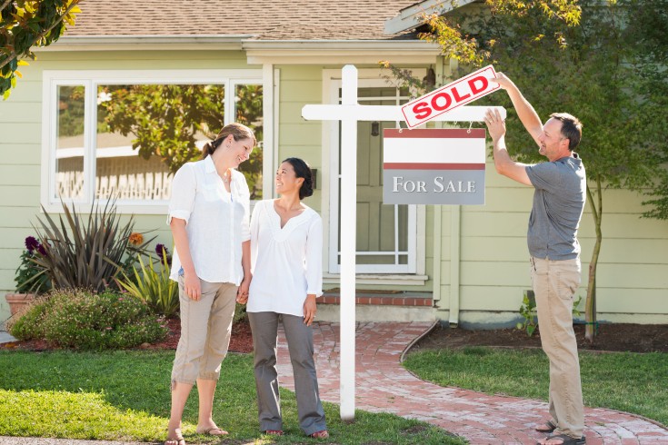 agent puts a sold sign for new homebuyers