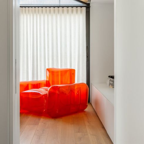 A bright-coloured inflatable chair sitting in a room