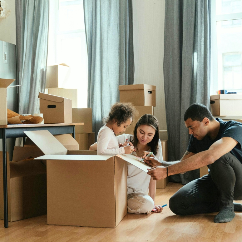 Couple unpacking boxes with their child in their new home