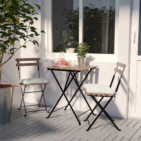 The Taerno wooden bistro set from IKEA in a small patio space