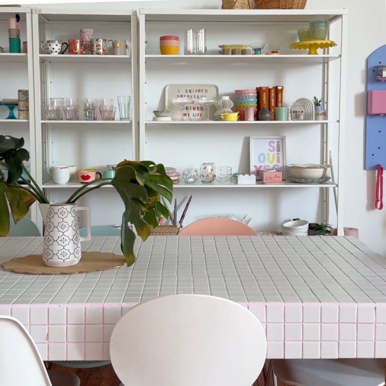 a colourful tiled table and shelves filled with accessories