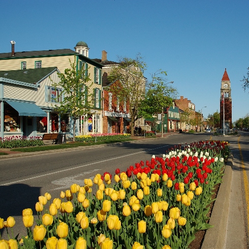 The memorial clock tower, tulips and historic buildings on Queen Street in Niagara-on-the-Lake, Ontario