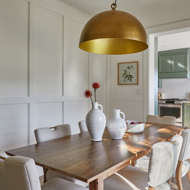 Bright white dining room with panelling and gold lighting