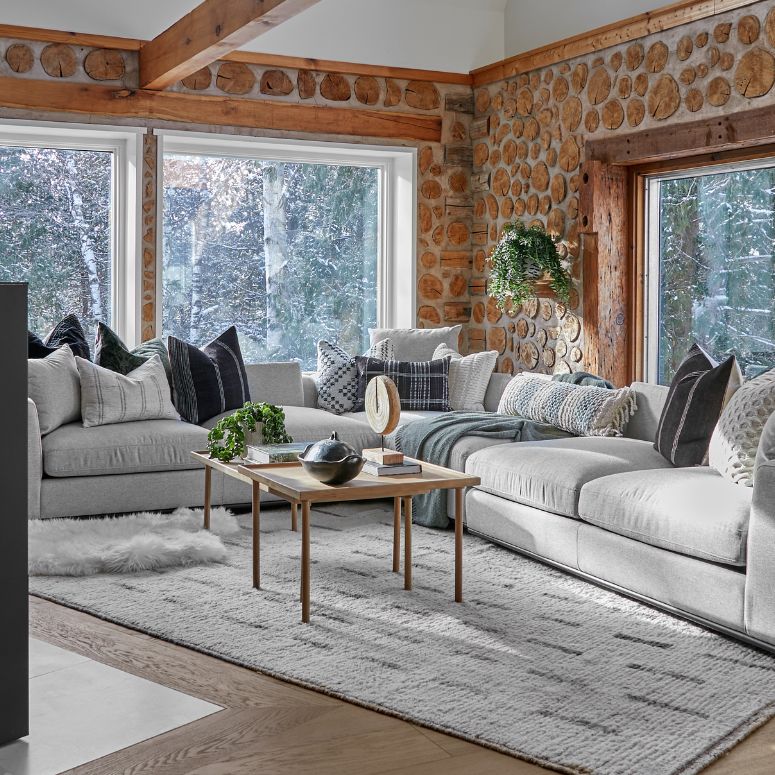 Bright living room with stone walls and grey sofas