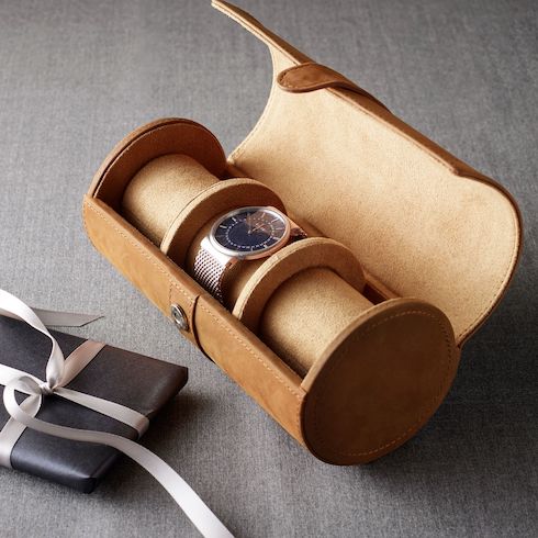 Grant Leather Watch Roll by Pottery Barn with a watch inside on grey wood with a wrapped present beside it as part of HGTV Canada's 10 Gift Ideas for the Men in Your Life