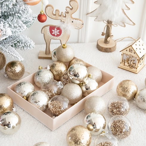 An assortment of elegant metallic round ornaments set in and around a rectangle tray on a festive table.